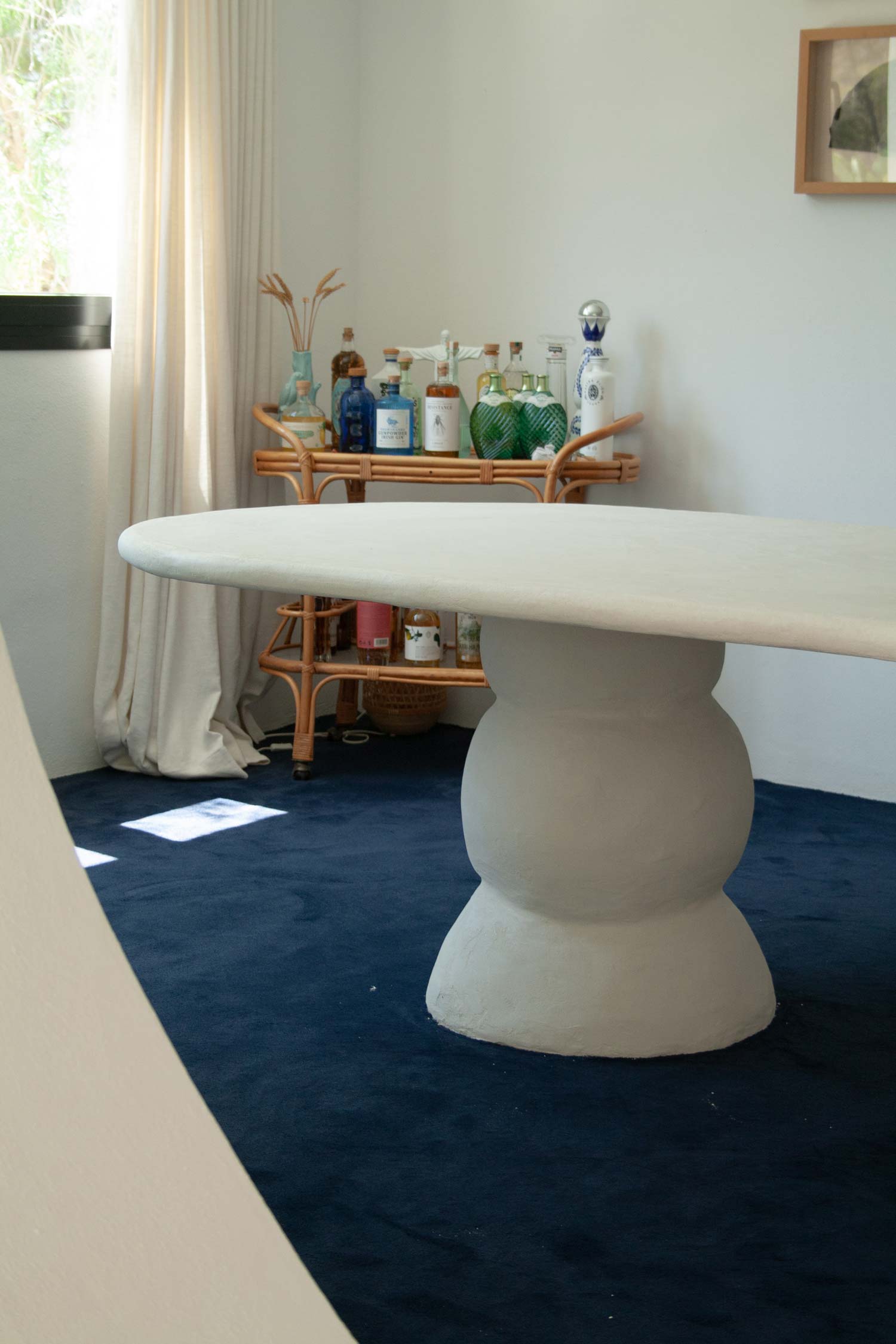Custom made dining table, Ibiza, called “Artefact dining table“ with two artefact, totem like bases and a long oval playful imperfect shape tabletop. Materials are hempcrete, limestone, wood, mortex. design by studio jannis schaefer