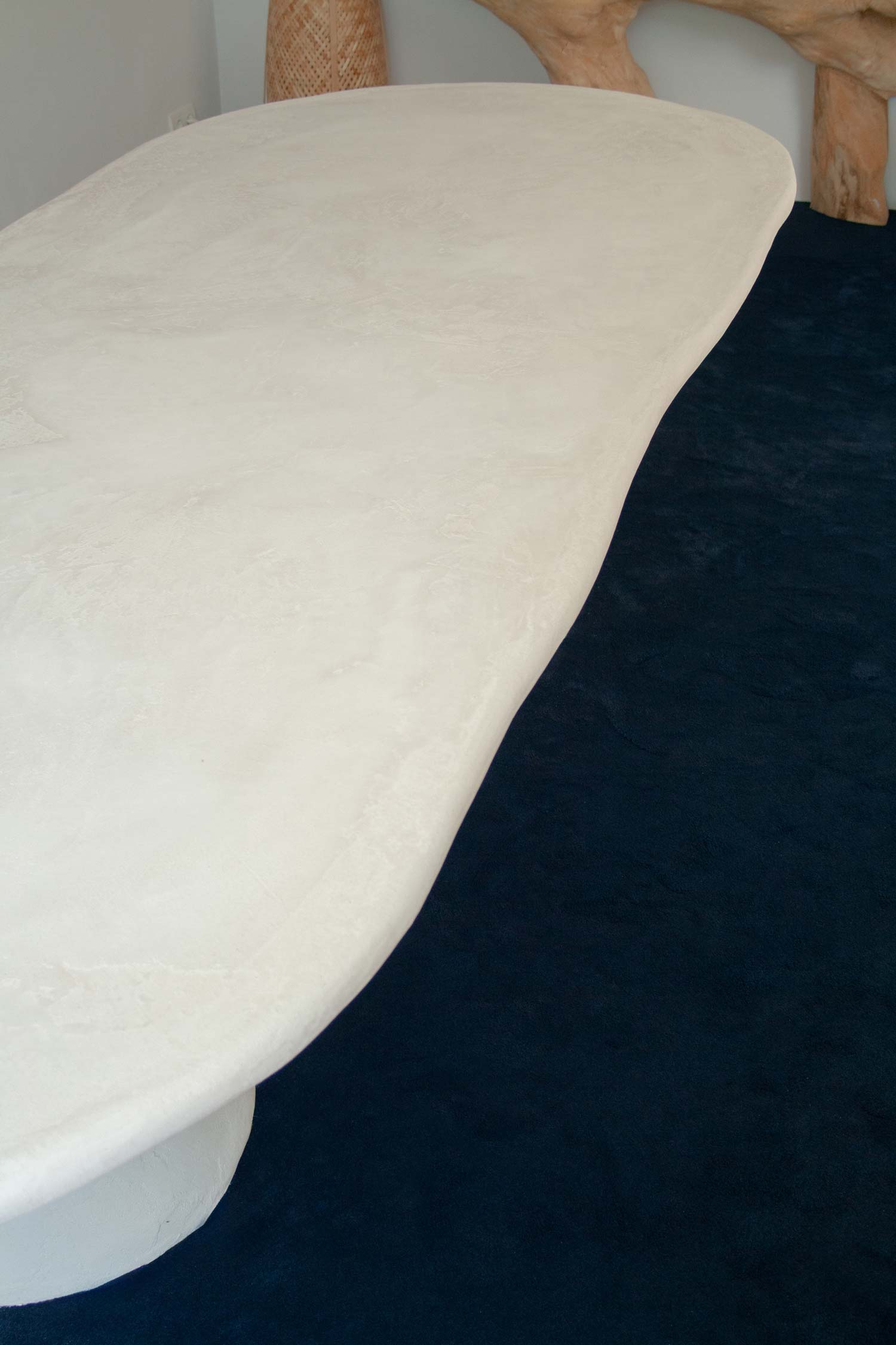 Custom made dining table, Ibiza, called “Artefact dining table“ with two artefact, totem like bases and a long oval playful imperfect shape tabletop. Materials are hempcrete, limestone, wood, mortex. design by studio jannis schaefer