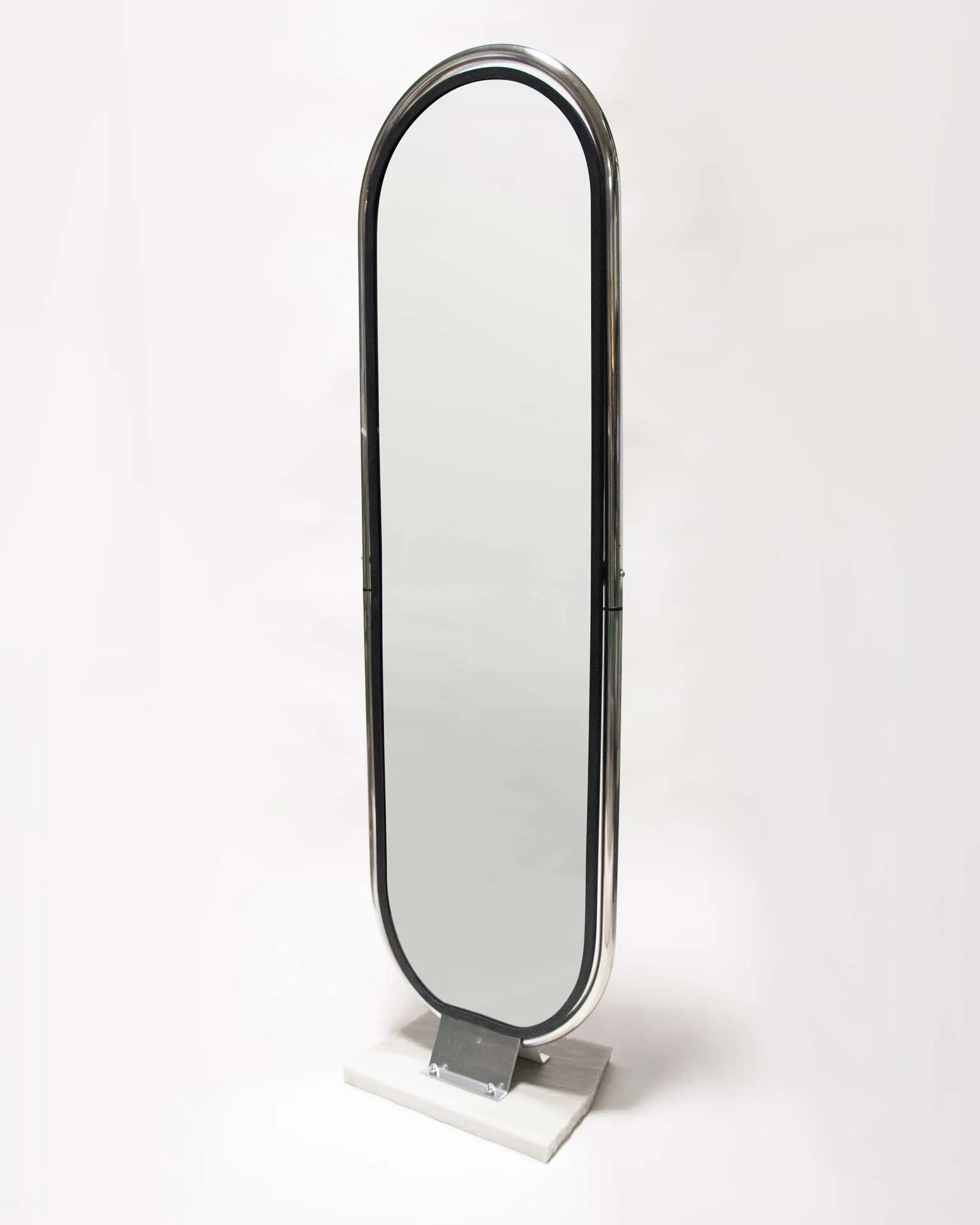 A mirror created by Jannis Schäfer Studio, made from upcycled theft detectors and a reclaimed marble tabletop. The design features a tall, narrow, swingable mirror framed in a chrome structure with a marble base. This object, titled 'Stealing Beauty,' is part of a series of recycled and transformed designs.
