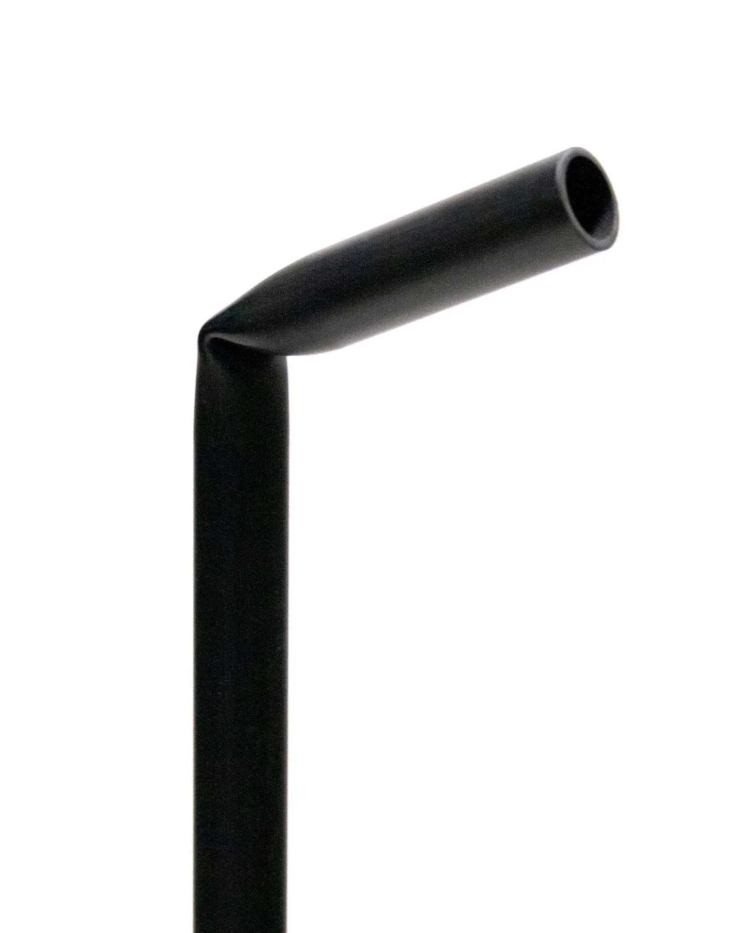 A toilet paper holder created by Jannis Schäfer Studio, made from a reclaimed PVC tube. The design features a black, L-shaped frame with one vertical rod holding a roll of toilet paper at the top and a second vertical rod holding multiple spare rolls. This object is part of a series of upcycled, recycled, and transformed designs.