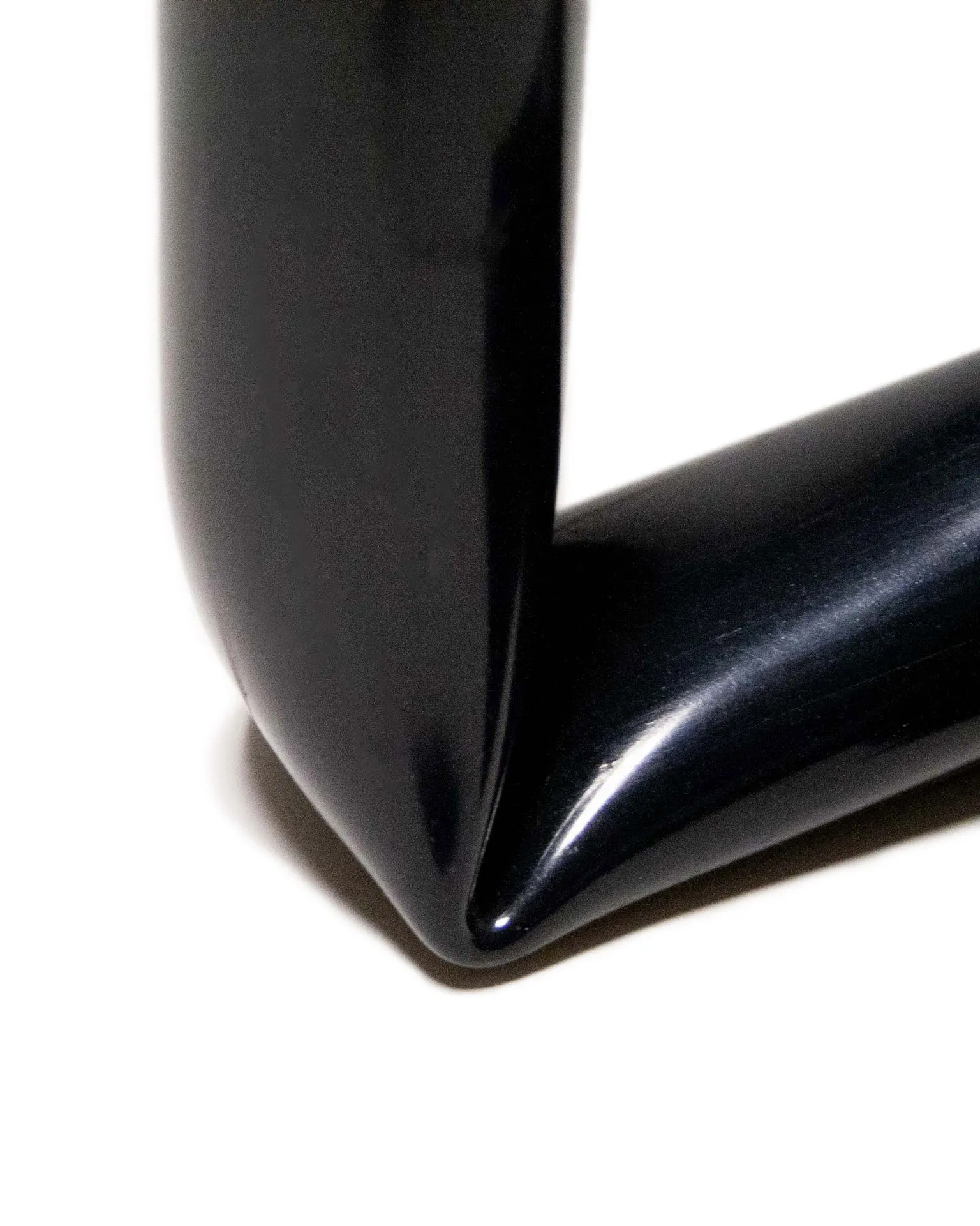 A candle holder created by Jannis Schäfer Studio, made from upcycled PVC tube. The design features a unique, twisted form with two cylindrical openings for candles. This transformed and reclaimed material piece is part of a series of derivative designs.