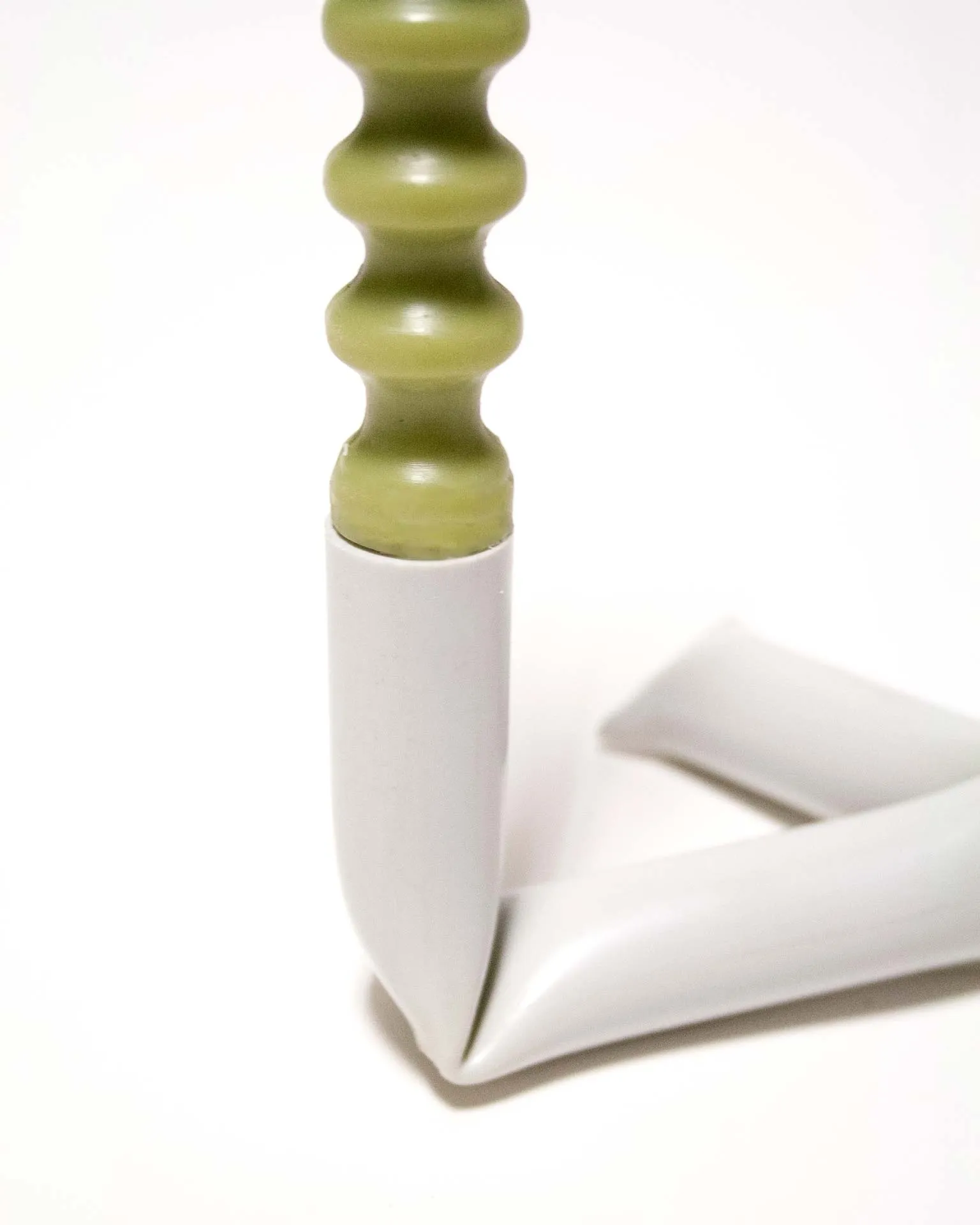 "A sleek black candle holder made from an upcycled PVC tube, creatively bent into an L-shape. Designed by Jannis Schäfer Studio, the piece demonstrates innovative use of reclaimed materials and is part of the 'Derivatives' series, emphasizing sustainable design practices.”