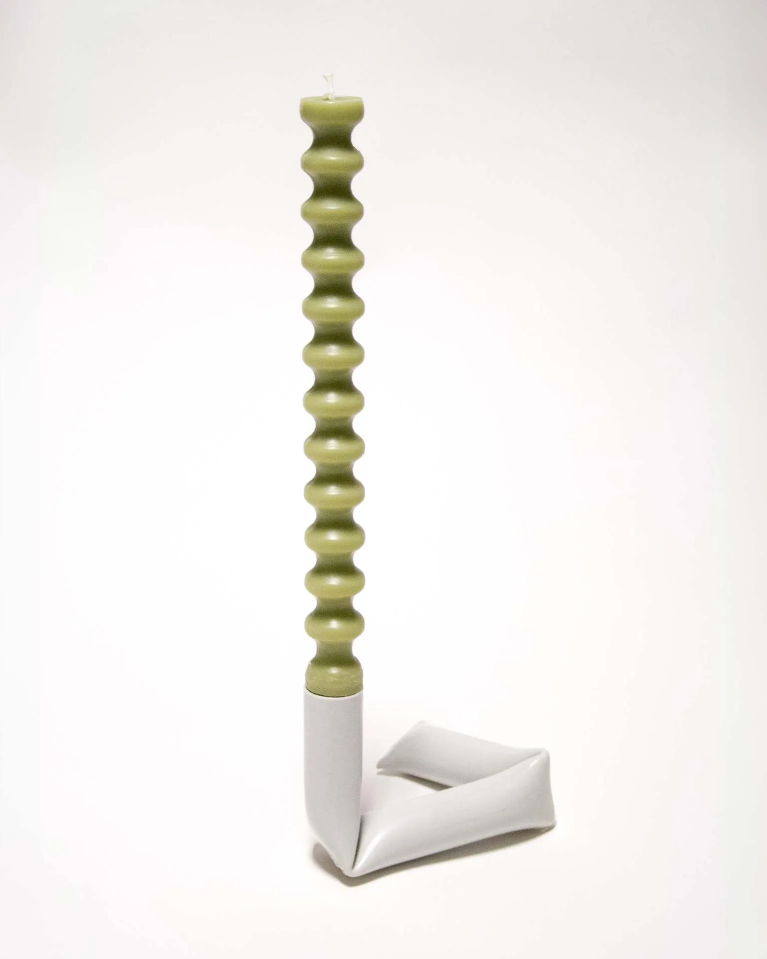 "A sleek black candle holder made from an upcycled PVC tube, creatively bent into an L-shape. Designed by Jannis Schäfer Studio, the piece demonstrates innovative use of reclaimed materials and is part of the 'Derivatives' series, emphasizing sustainable design practices.”