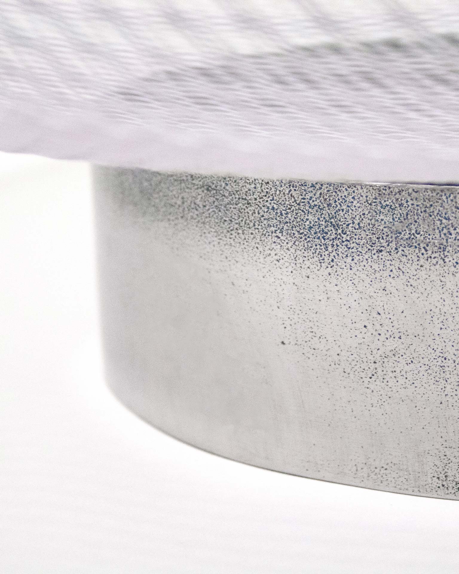 "A minimalist fruit bowl designed by Jannis Schäfer Studio, crafted from an upcycled ventilator shield. The bowl features a circular mesh design, highlighting the studio's commitment to transforming reclaimed materials. This piece is part of the 'Derivatives' series, focusing on innovative and sustainable design.”