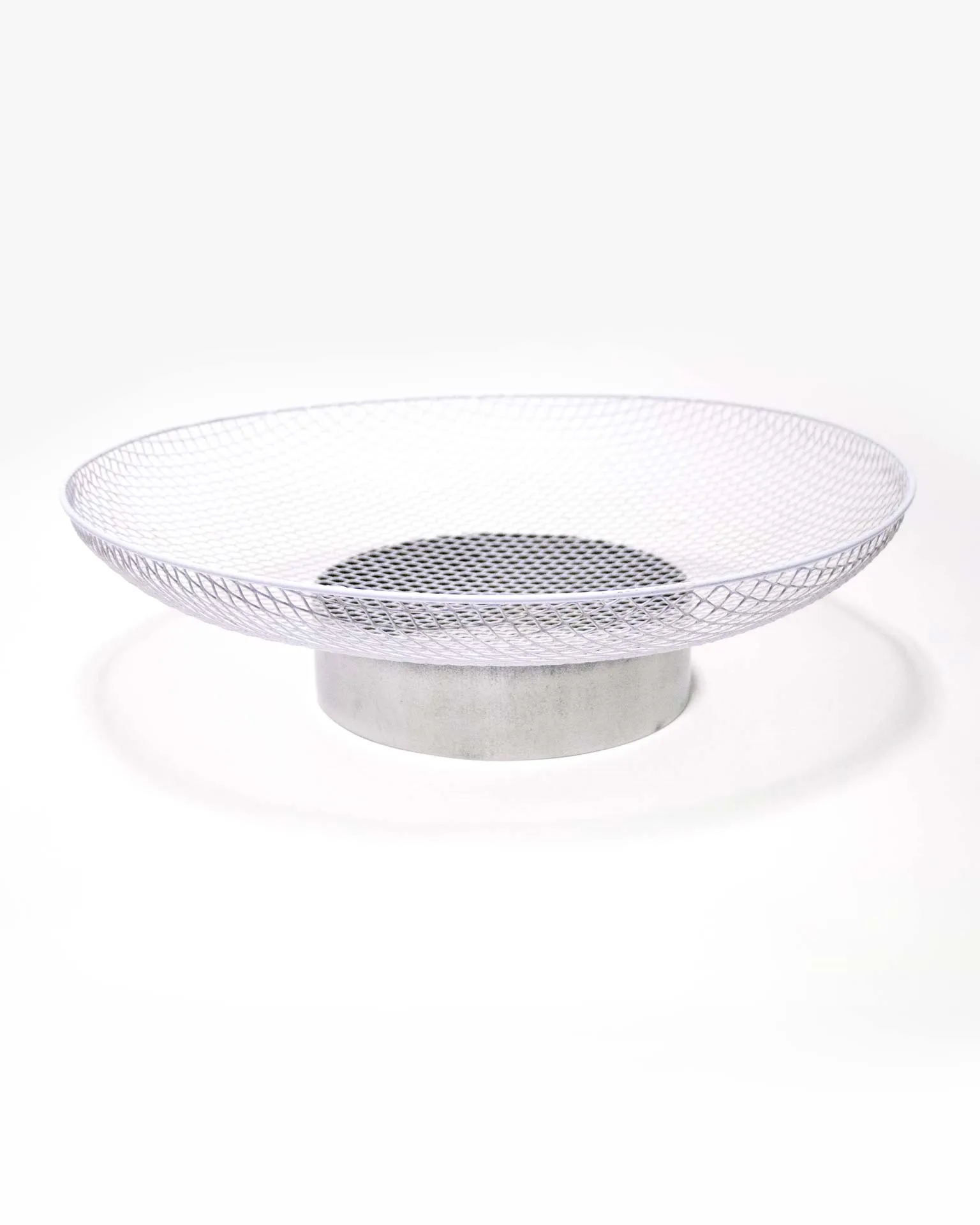 "A minimalist fruit bowl designed by Jannis Schäfer Studio, crafted from an upcycled ventilator shield. The bowl features a circular mesh design, highlighting the studio's commitment to transforming reclaimed materials. This piece is part of the 'Derivatives' series, focusing on innovative and sustainable design.”