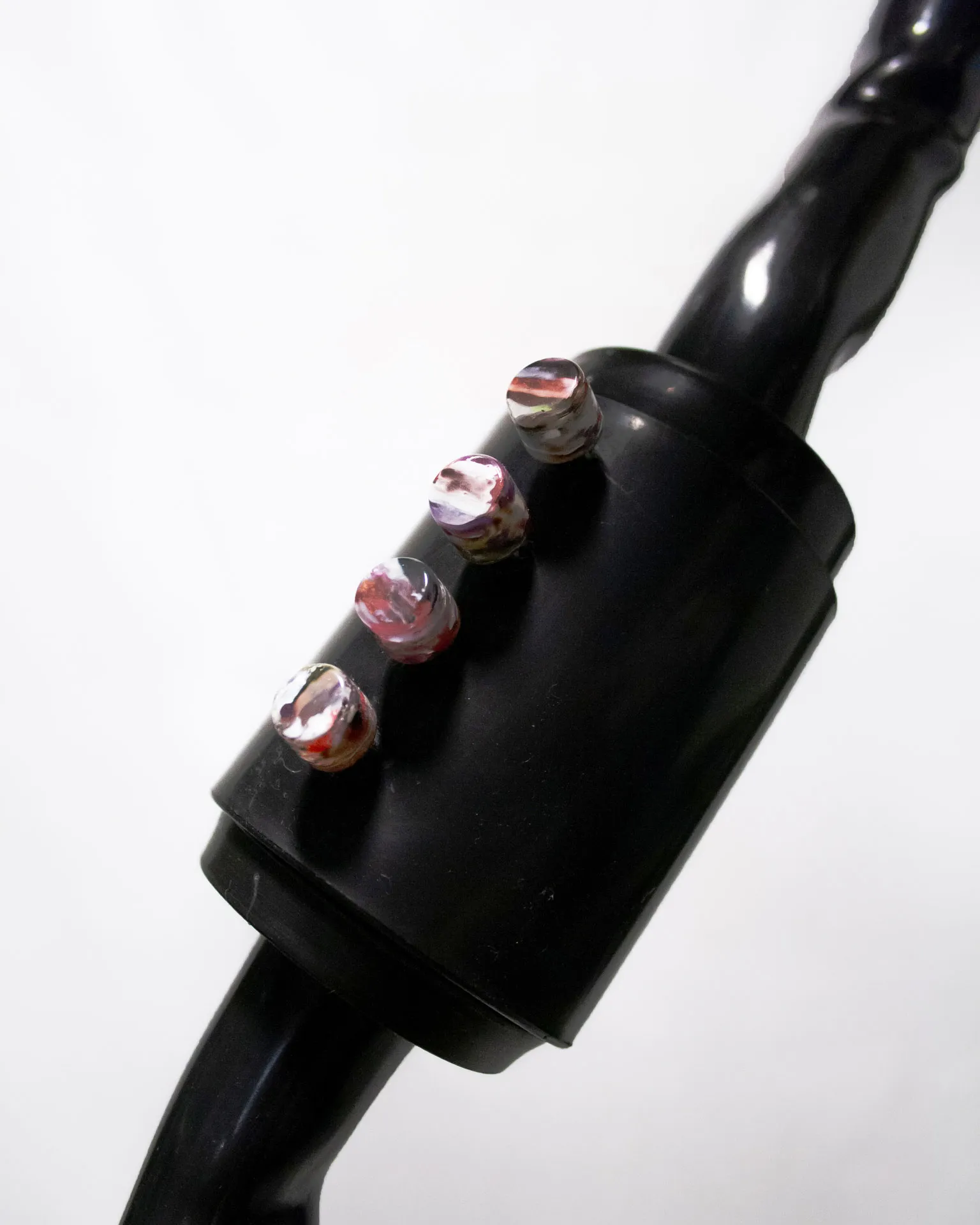 The 'Bent Pipe Blower,' created by Jannis Schäfer Studio, is a ventilator sculpture made from a reclaimed PVC tube and Precious Plastic samples as knobs and buttons. The design features a standing fan with a curved black pipe as the stand, a white circular base, and a clear fan head. This upcycled, recycled, and transformed piece is part of a series of derivative designs.