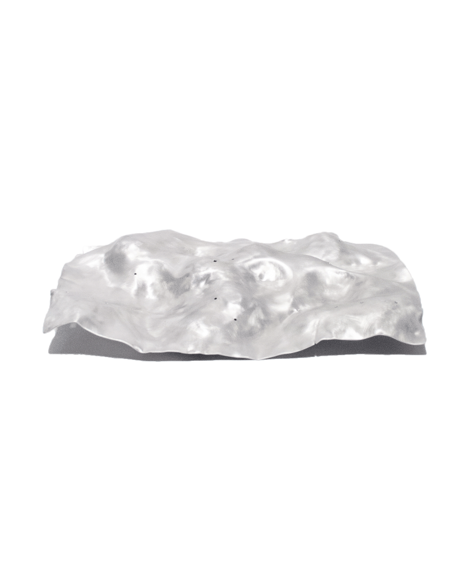 The 'Silver Platter,' created by Jannis Schäfer Studio, is made from a reclaimed aluminum motherboard tray. The design features a textured, undulating surface with a metallic finish. This upcycled, recycled, and transformed piece is part of a series of derivative designs.