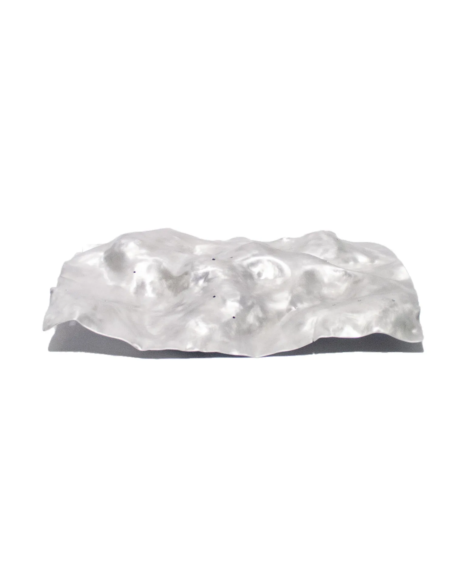 The 'Silver Platter,' created by Jannis Schäfer Studio, is made from a reclaimed aluminum motherboard tray. The design features a textured, undulating surface with a metallic finish. This upcycled, recycled, and transformed piece is part of a series of derivative designs.